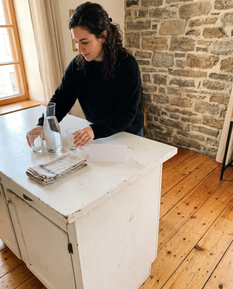 Une hôte prépare une carafe d'eau et des verres pour ses invités